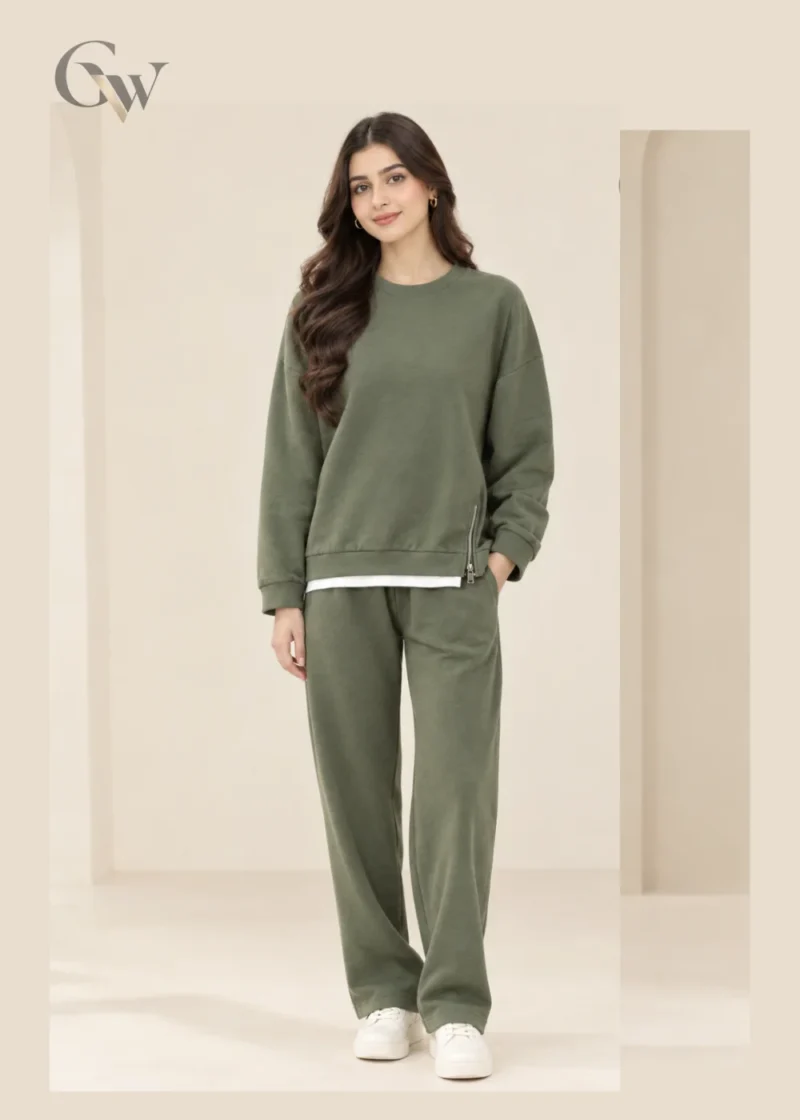 Woman wearing an olive green crew-neck sweatshirt with side-zip details and matching wide-leg trousers