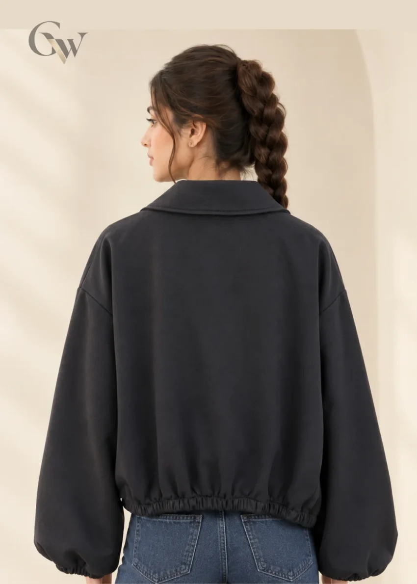 Woman wearing a black cropped double-breasted jacket with oversized lapels and four front buttons