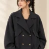 Woman wearing a black cropped double-breasted jacket with oversized lapels and four front buttons