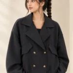 Woman wearing a black cropped double-breasted jacket with oversized lapels and four front buttons
