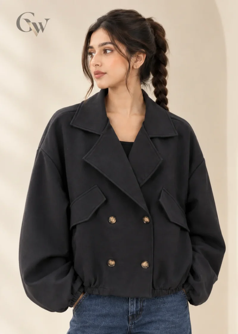 Woman wearing a black cropped double-breasted jacket with oversized lapels and four front buttons