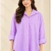 Woman wearing a lavender and white striped button-down shirt with a pointed collar and long sleeves.