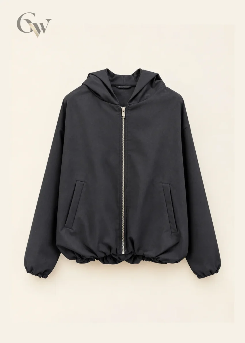 Woman wearing a charcoal zip-up hooded jacket with long sleeves and front pockets