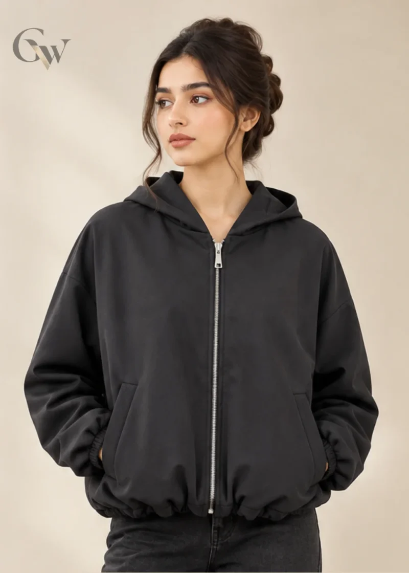 Woman wearing a charcoal zip-up hooded jacket with long sleeves and front pockets