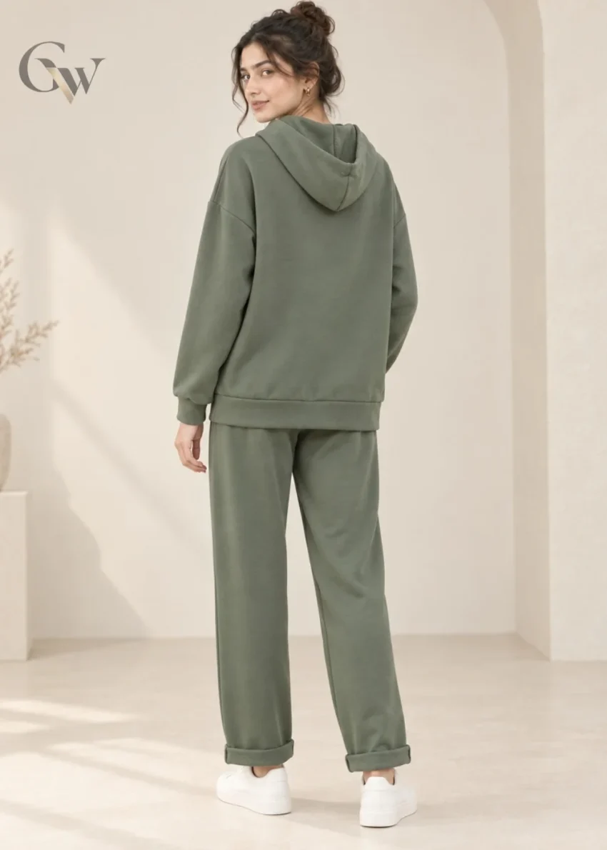 Woman wearing an olive green hooded co-ord set with white drawstrings and flap-detail pockets.